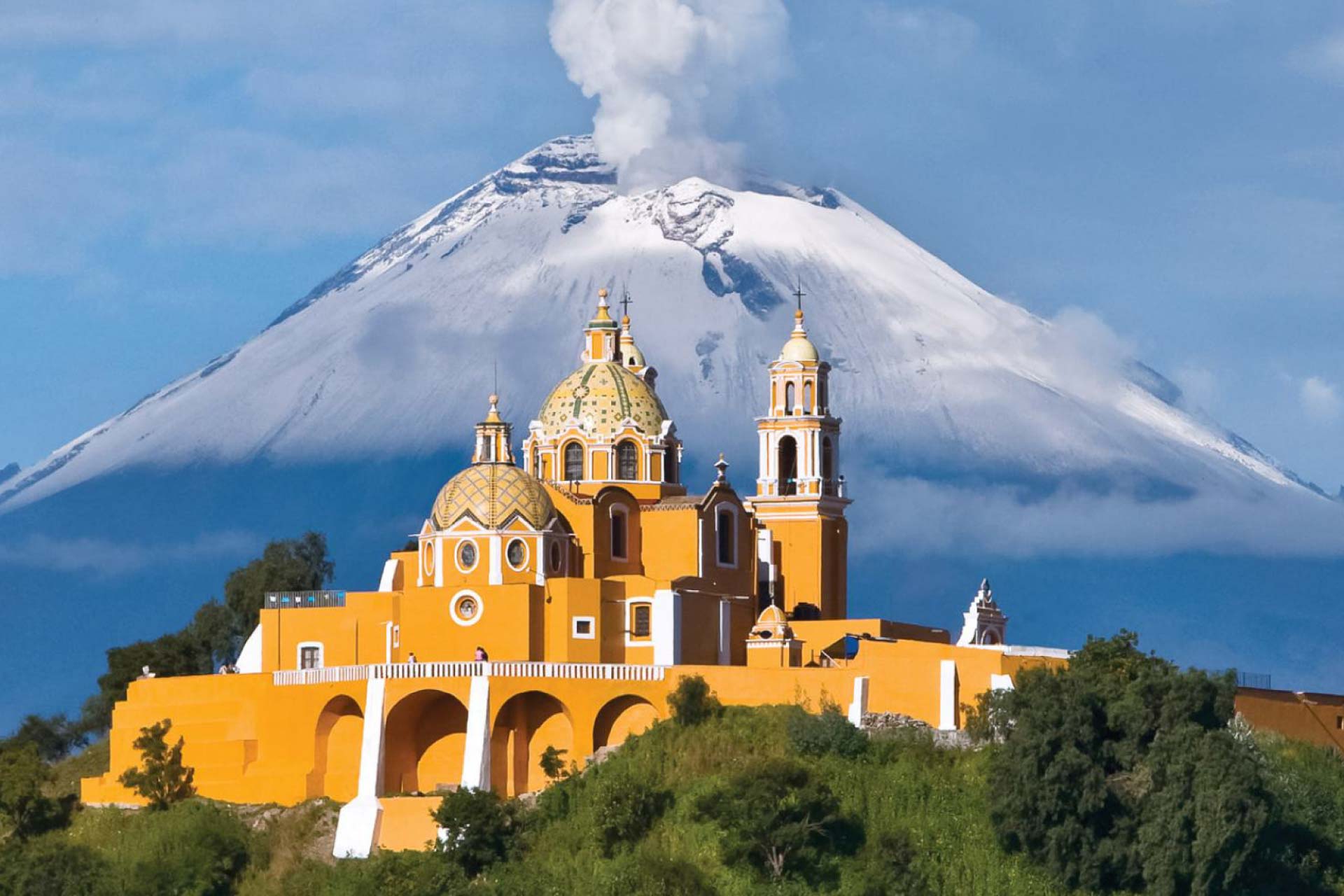 Impresionante imagen de la ciudad de Puebla al amanecer, mostrando sus calles coloniales y el volcán Popocatépetl al fondo